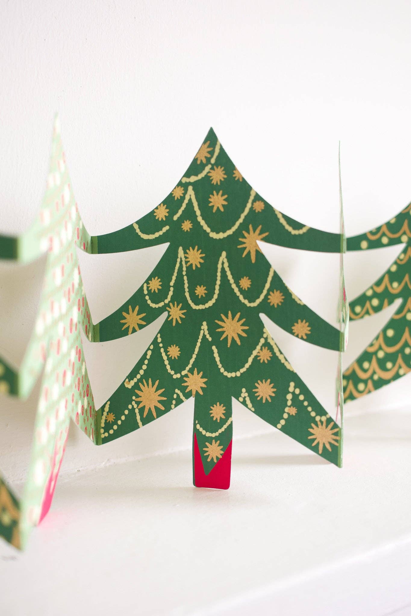 Decorative paper Christmas trees with gold accents on a white background