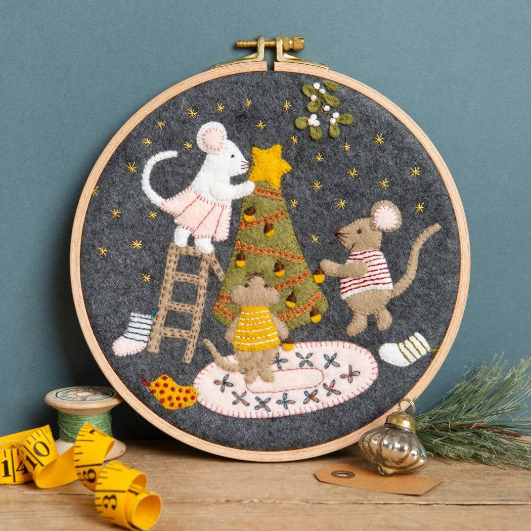 Embroidery hoop with festive design of mice around a Christmas tree on a blue background