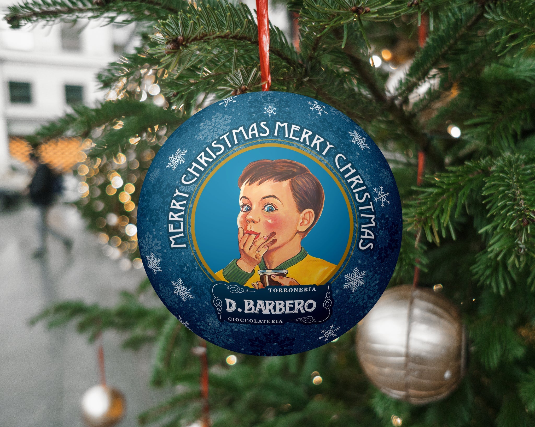 Decorative Christmas ornament with a child illustration and 'Merry Christmas' text, hanging on a tree.