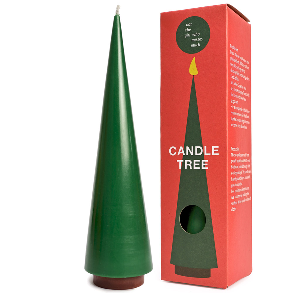 Green candle shaped like a tree next to its packaging box on a white background