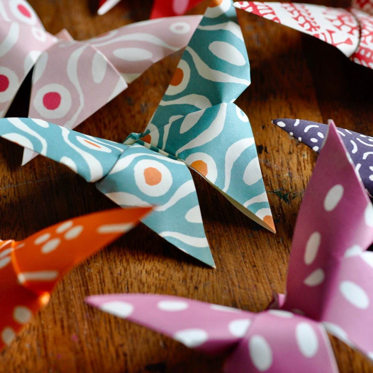Colorful paper pinwheels on a wooden surface