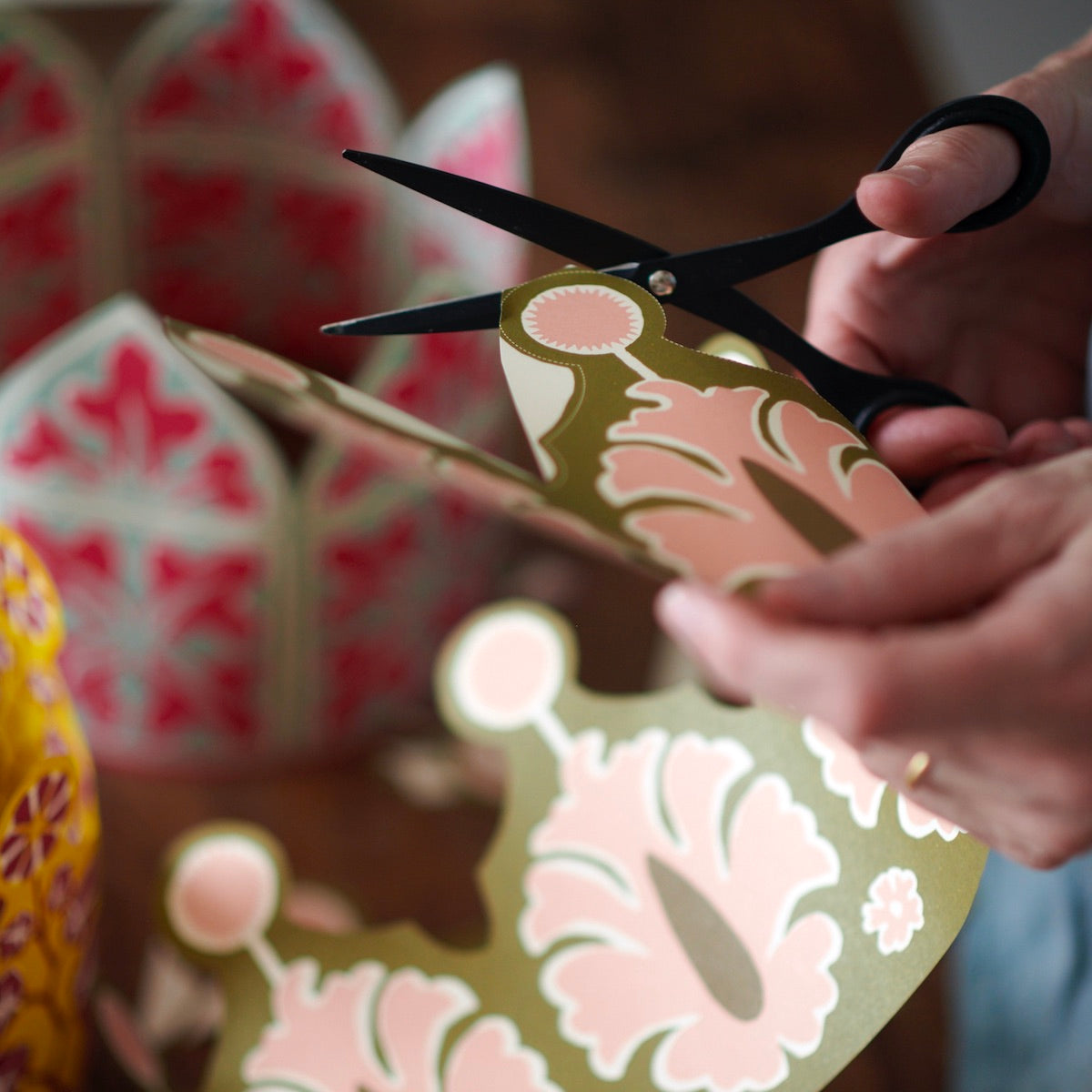 Person cutting a piece of patterned paper with scissors