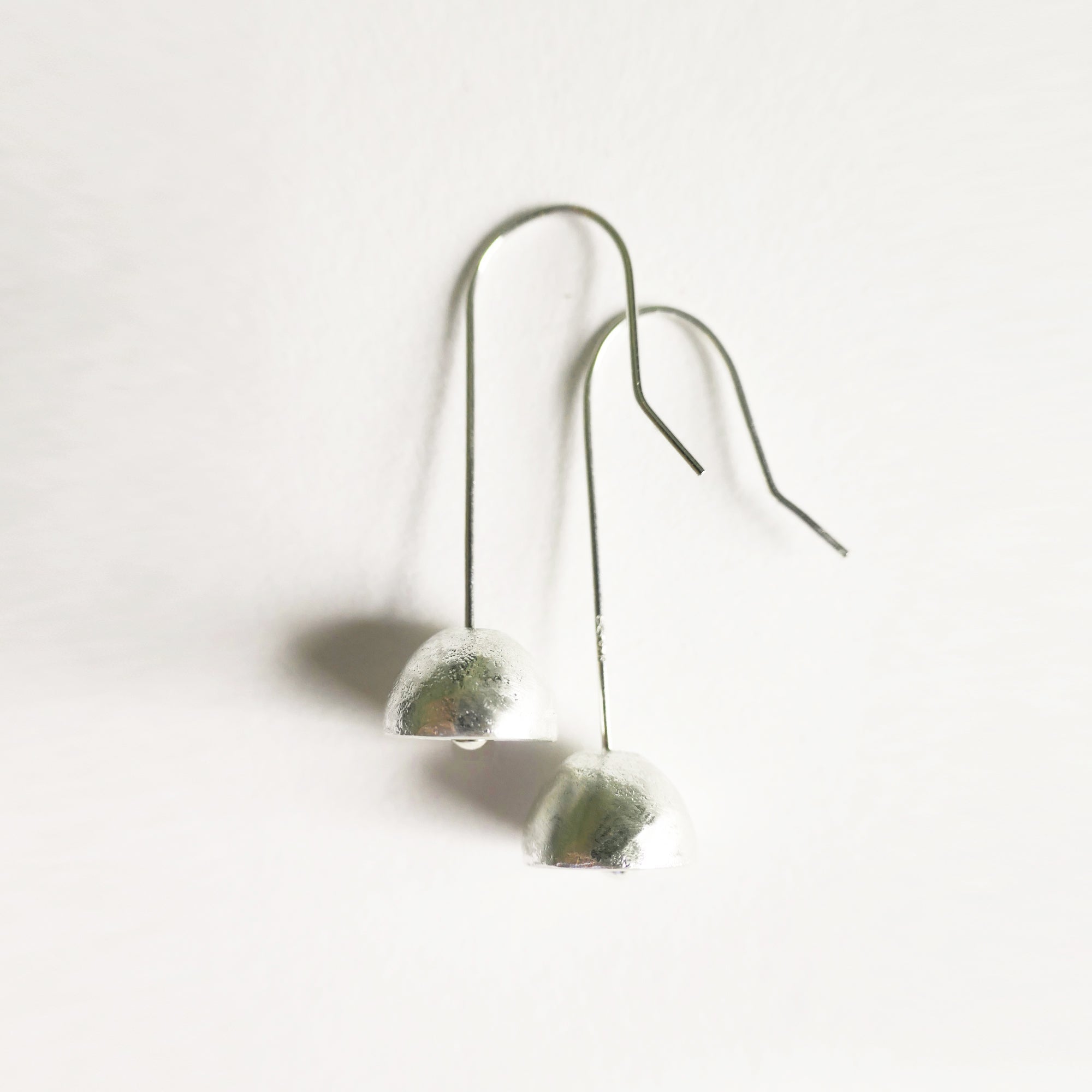 Pair of silver earrings dome shaped on a stone on a white background