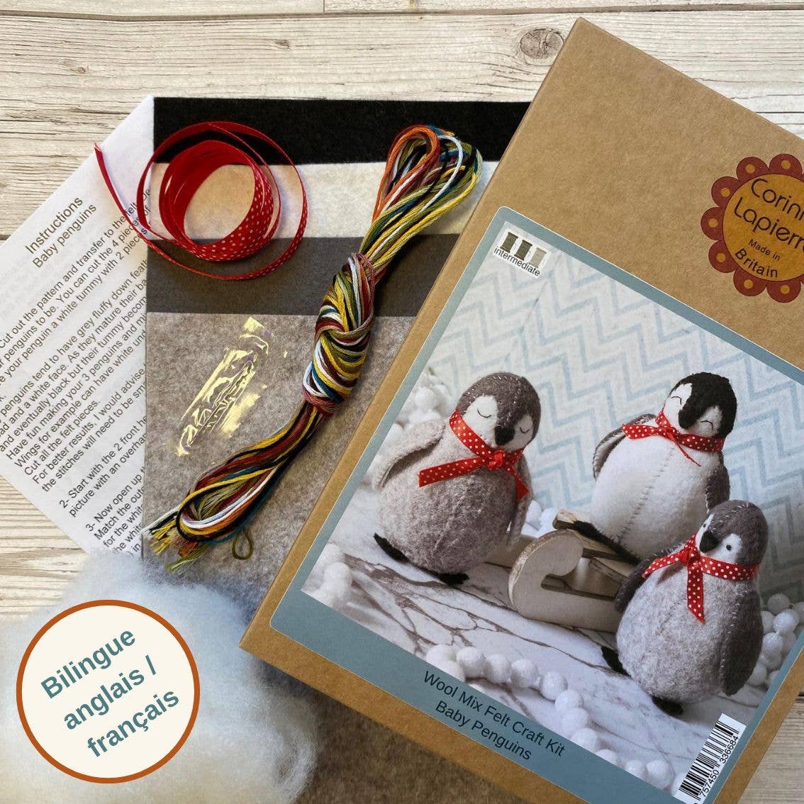 A kraft box with image of final product on, sheets of monochrome felt, colourful sewing threads, a needle and an instructions sheet.
