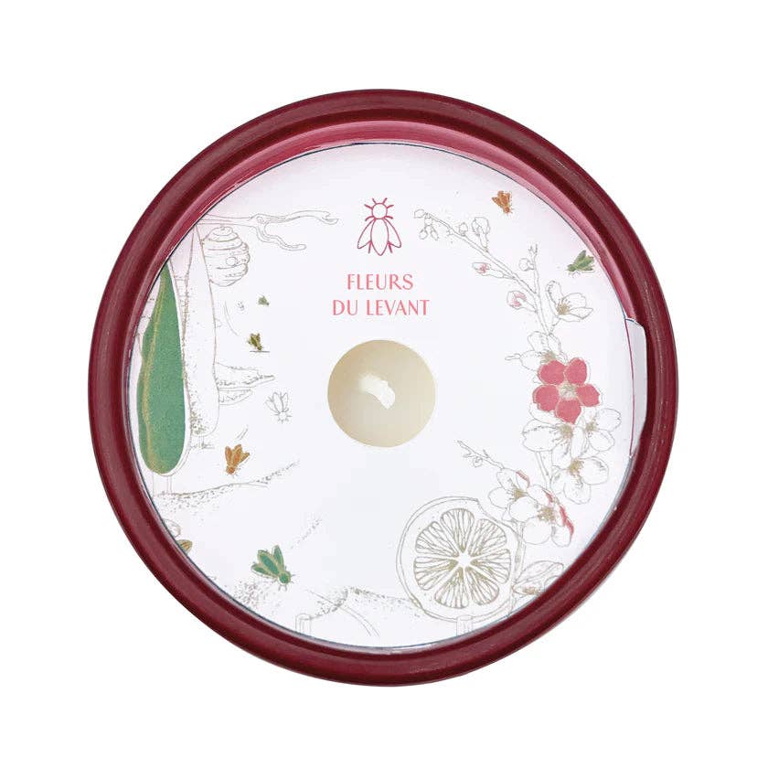 Wax protector lid showing the candle scent with illustrated design,