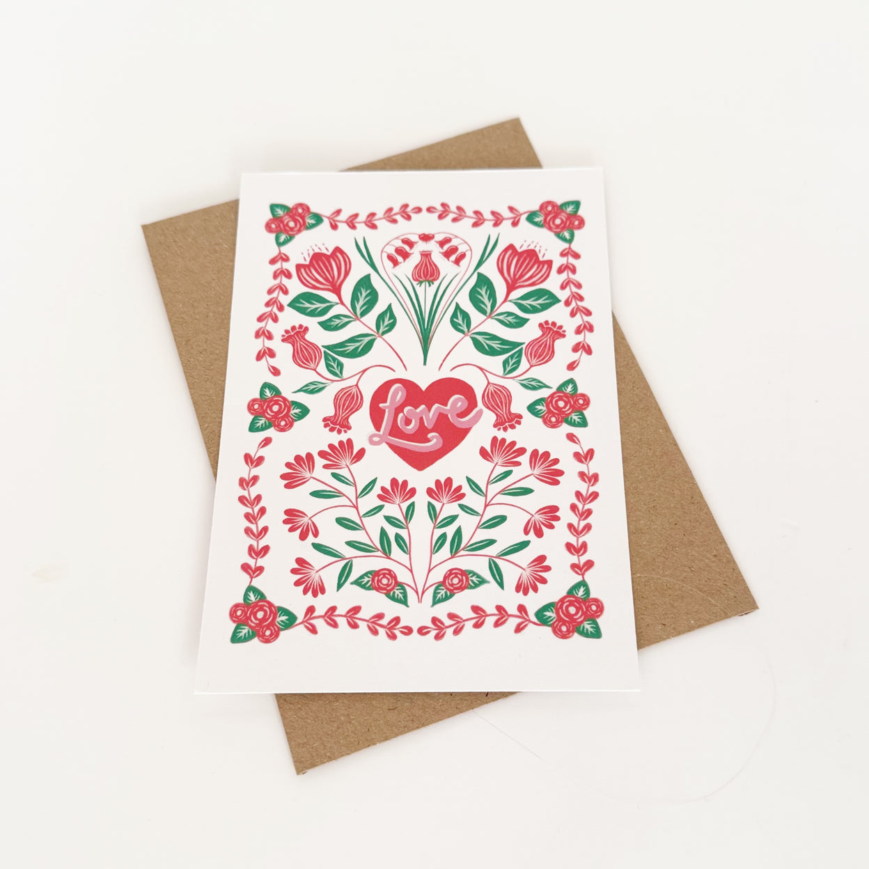 Greeting card with floral design and heart-shaped 'love' text on a white background