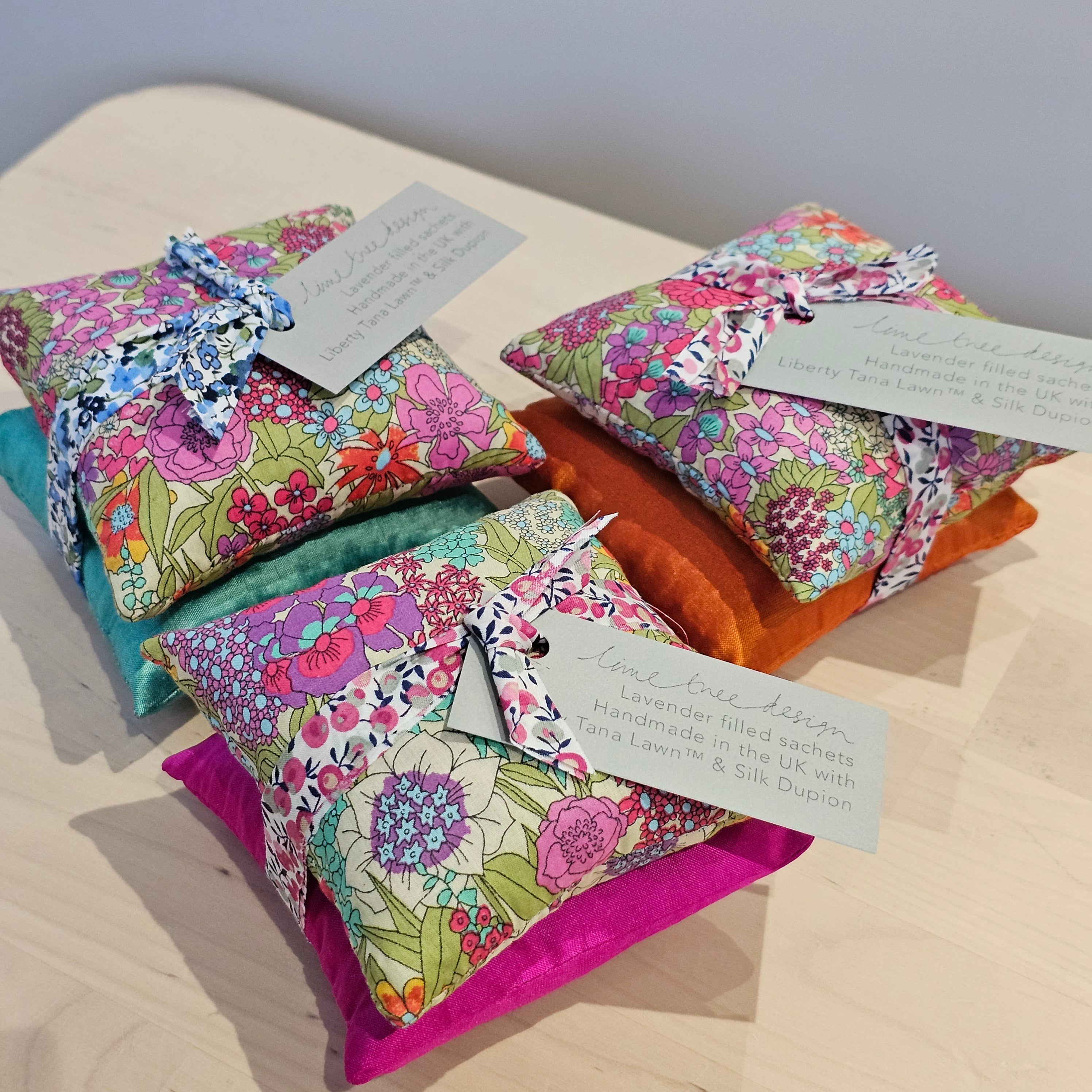 Colourful fabric pouches with floral patterns on a wooden surface