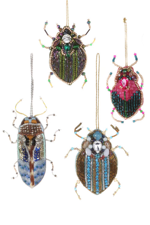 Decorative beetle ornaments with beadwork on a white background