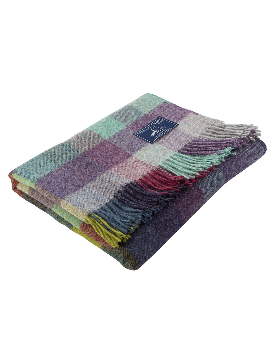 Multicolored checkered blanket with fringes on a white background