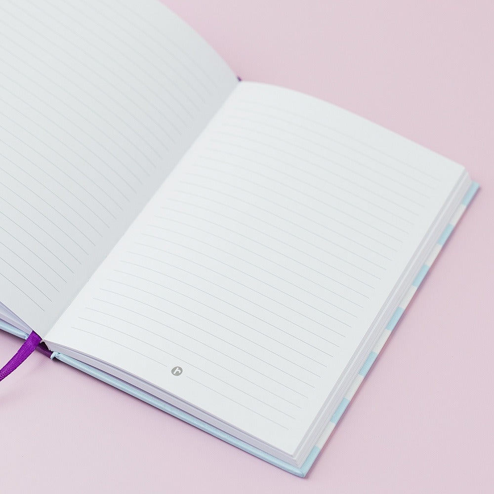 Open notebook with lined pages on a pink background