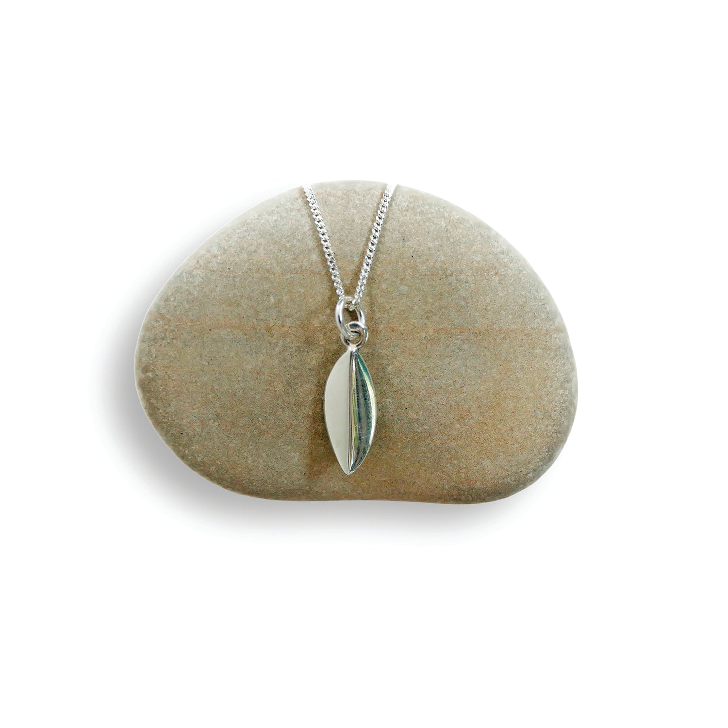 Silver leaf-shaped pendant on a chain, displayed on a green stone.