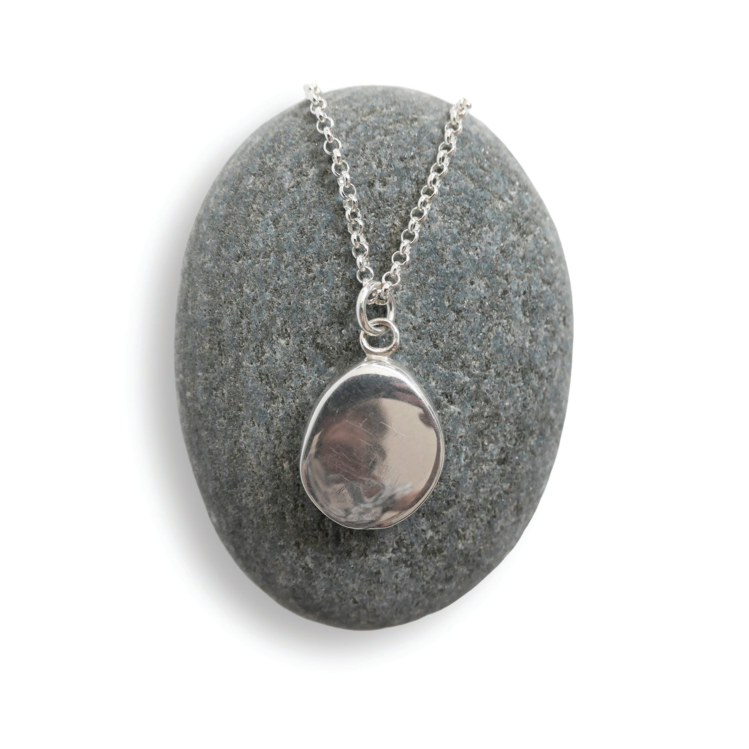 Silver necklace with a pendant on a gray stone