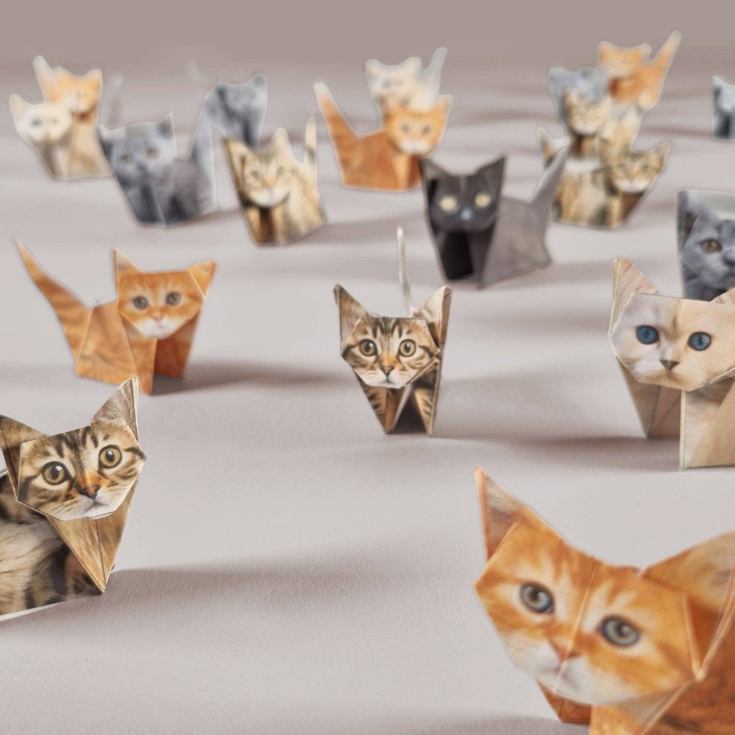 Image of various designs of folded origami paper cats on a neutral backdrop.