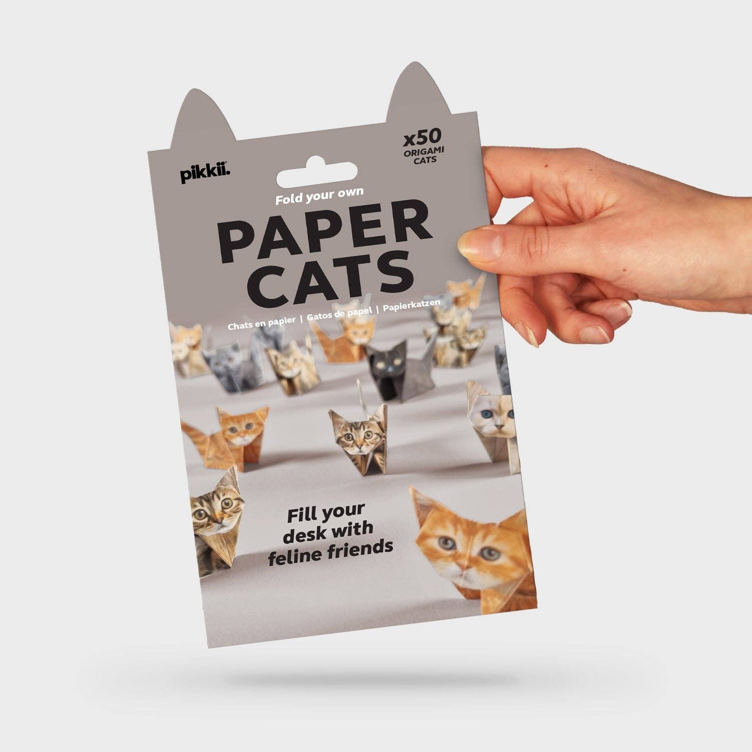 Grey packaging with Pikkii branding and cat ear shapes which reads ‘Fold your own Paper Cats” with image of origami folded paper cats in various designs. Additional text reads “Fill your desk with feline friends” and “x50 origami cats”