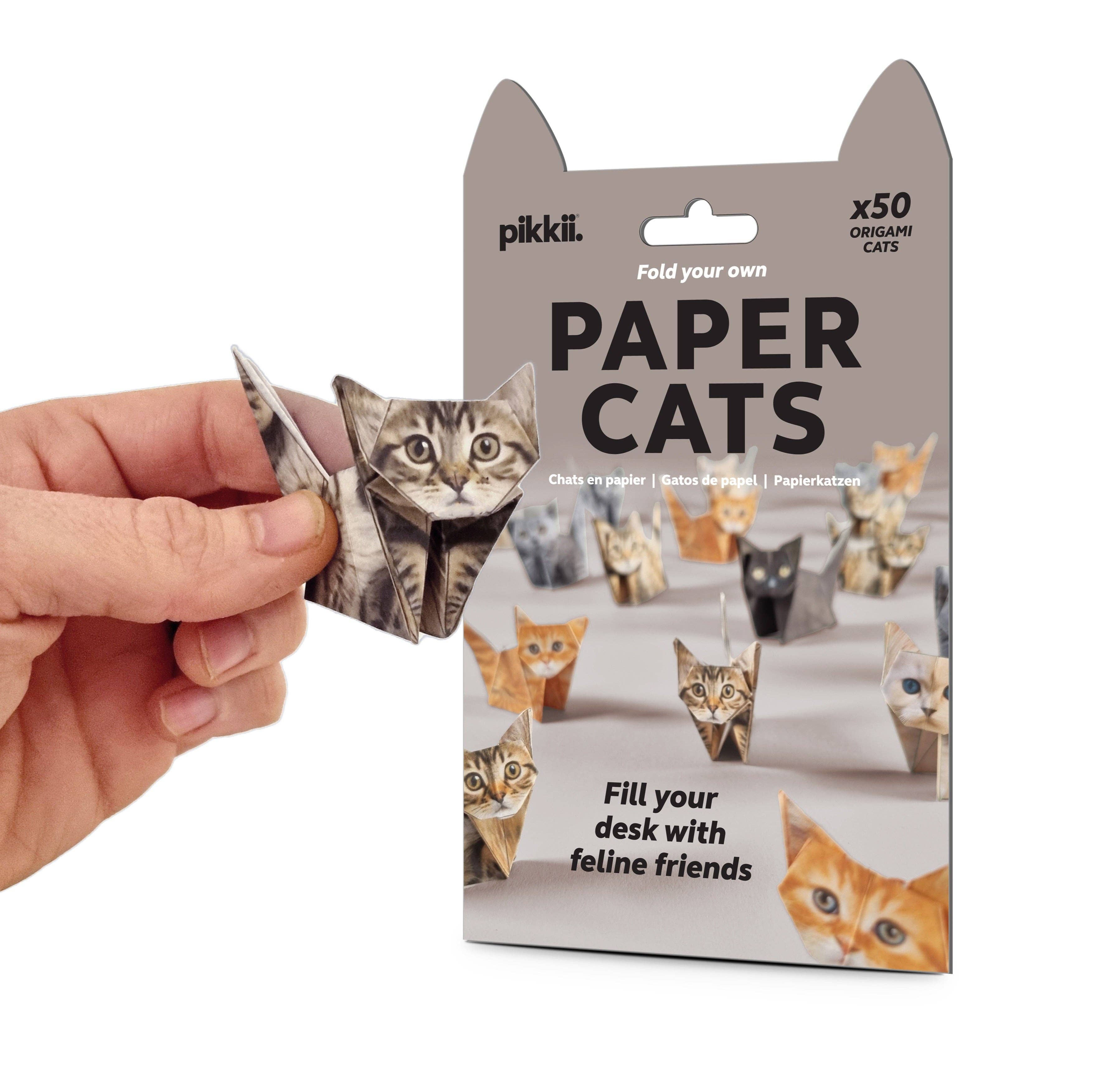 Package of paper cats with a hand holding one, on a white background