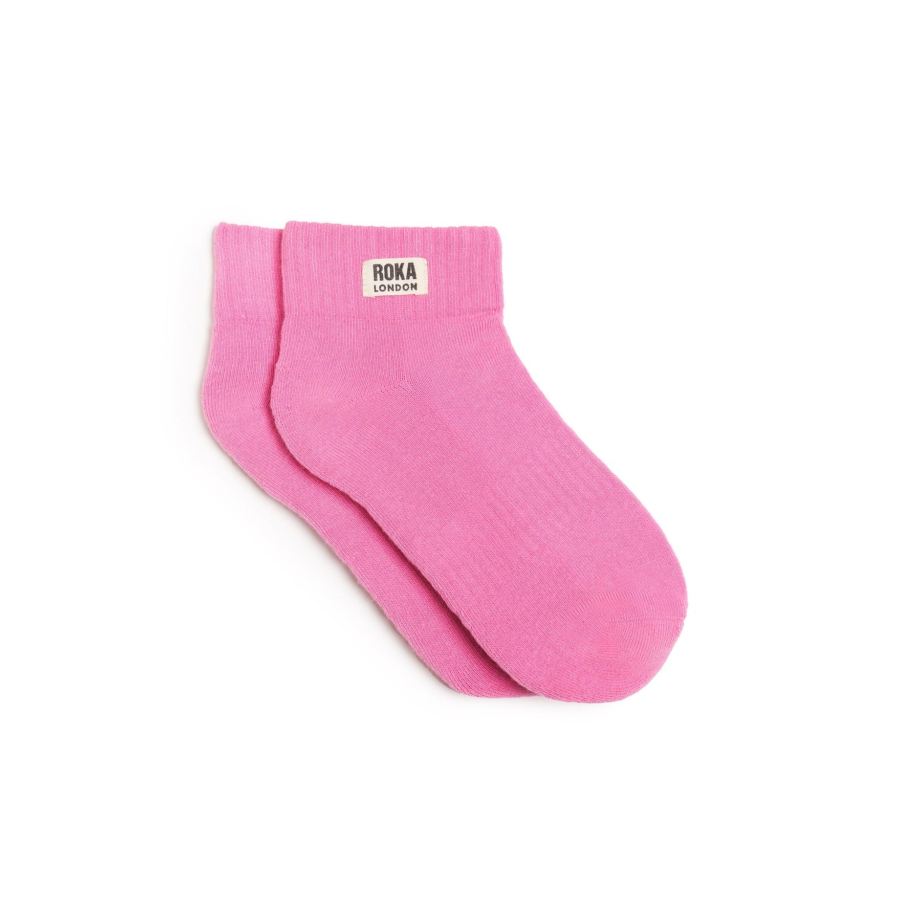 Pink socks with 'ROKA LONDON' label on a white background