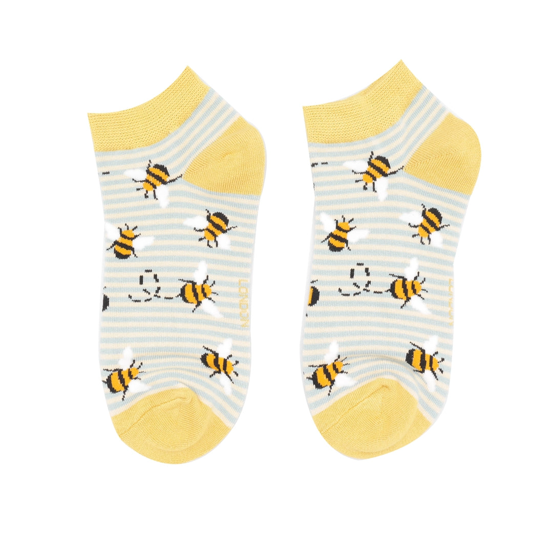 Two socks with bee pattern and yellow accents on a white background