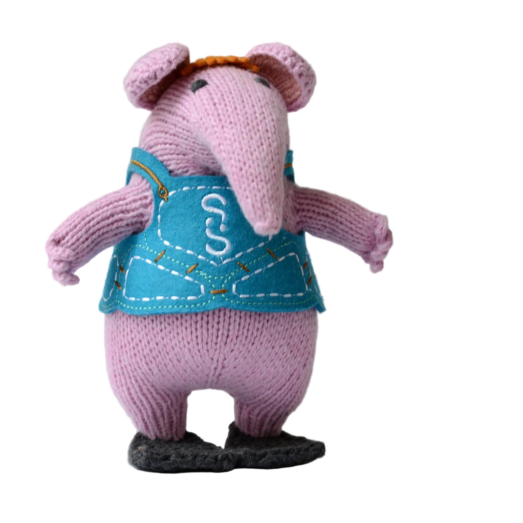 A knitted plush mouse character standing on a white surface against a light grey background. The plush has pink knit ears and legs, a blue vest with white embroidered stitching', and black shoes.