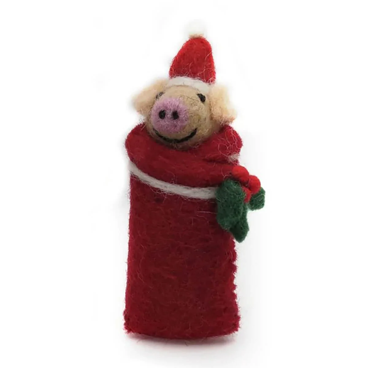 A handmade felt Christmas pig decoration wrapped in a red Santa hat and red blanket, with green holly leaves, on a white background.