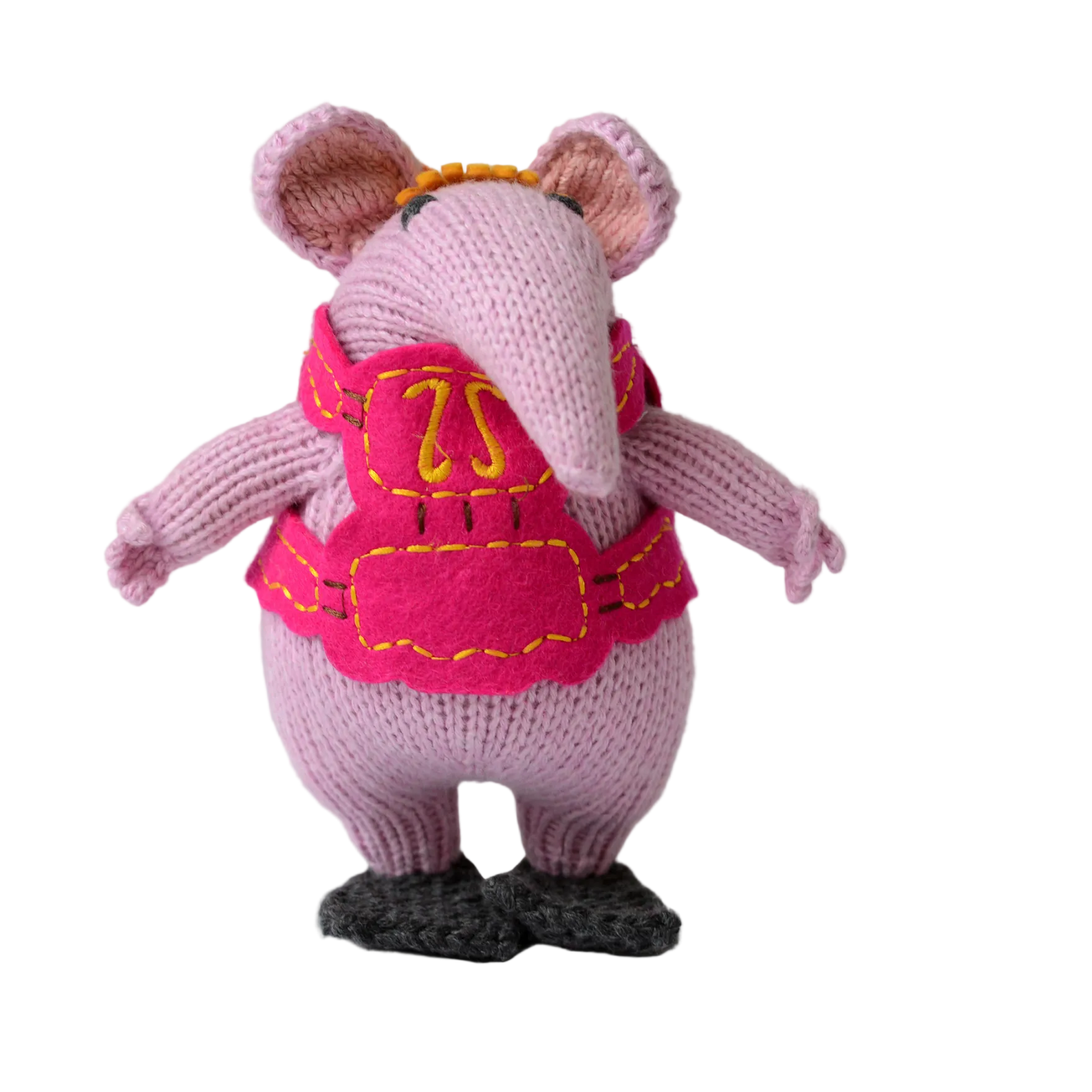 A knitted mouse figurine in light pink with a bright pink vest, yellow embroidered details, and dark gray shoes, shown against a plain light background.