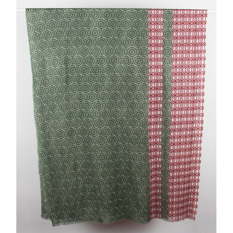 A rectangular fabric panel or curtain hanging flat against a plain light background, featuring a sage green field with a repeating circular spiral pattern and a vertical red border with a repeating geometric circle motif.