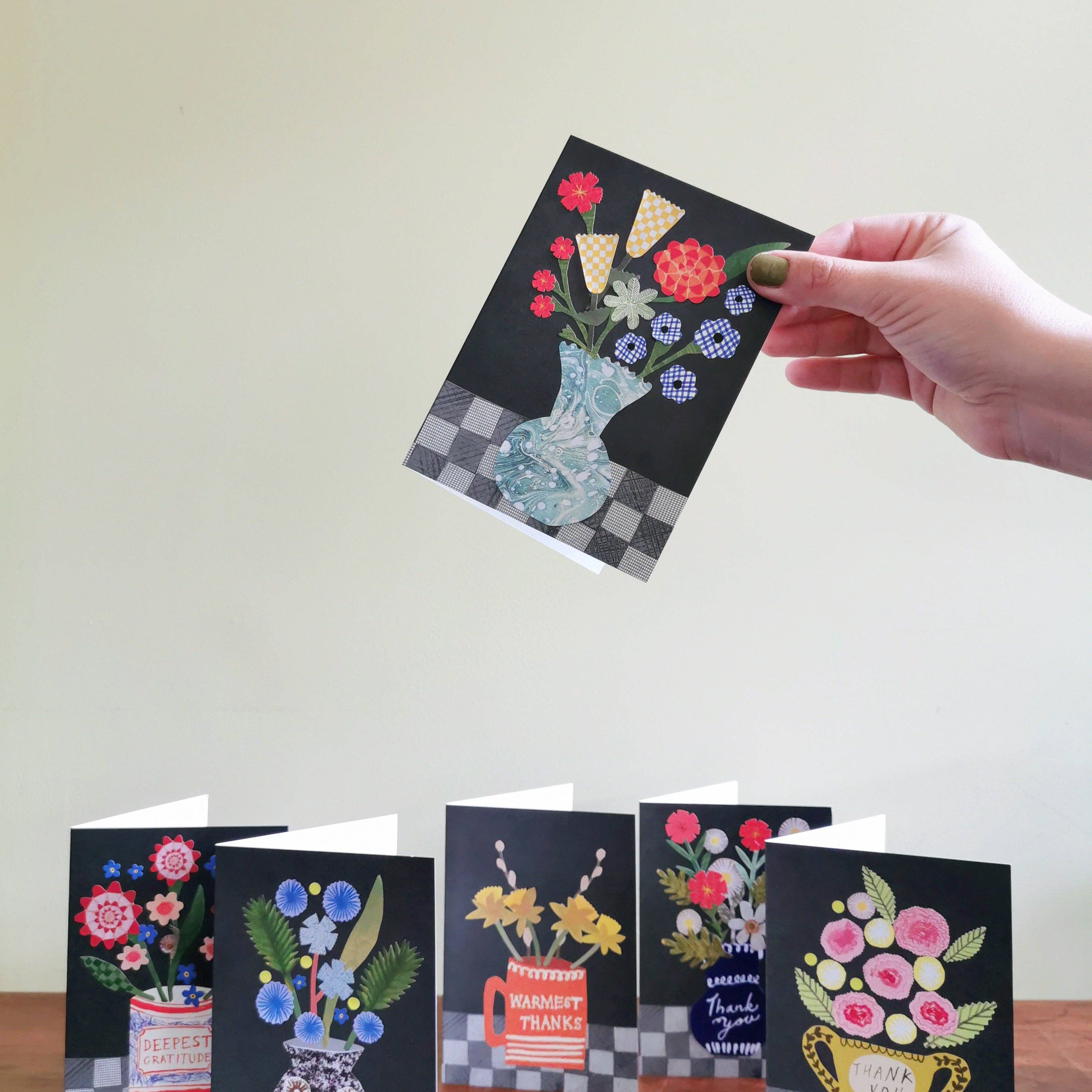 Set of greeting cards with floral designs on a wooden surface