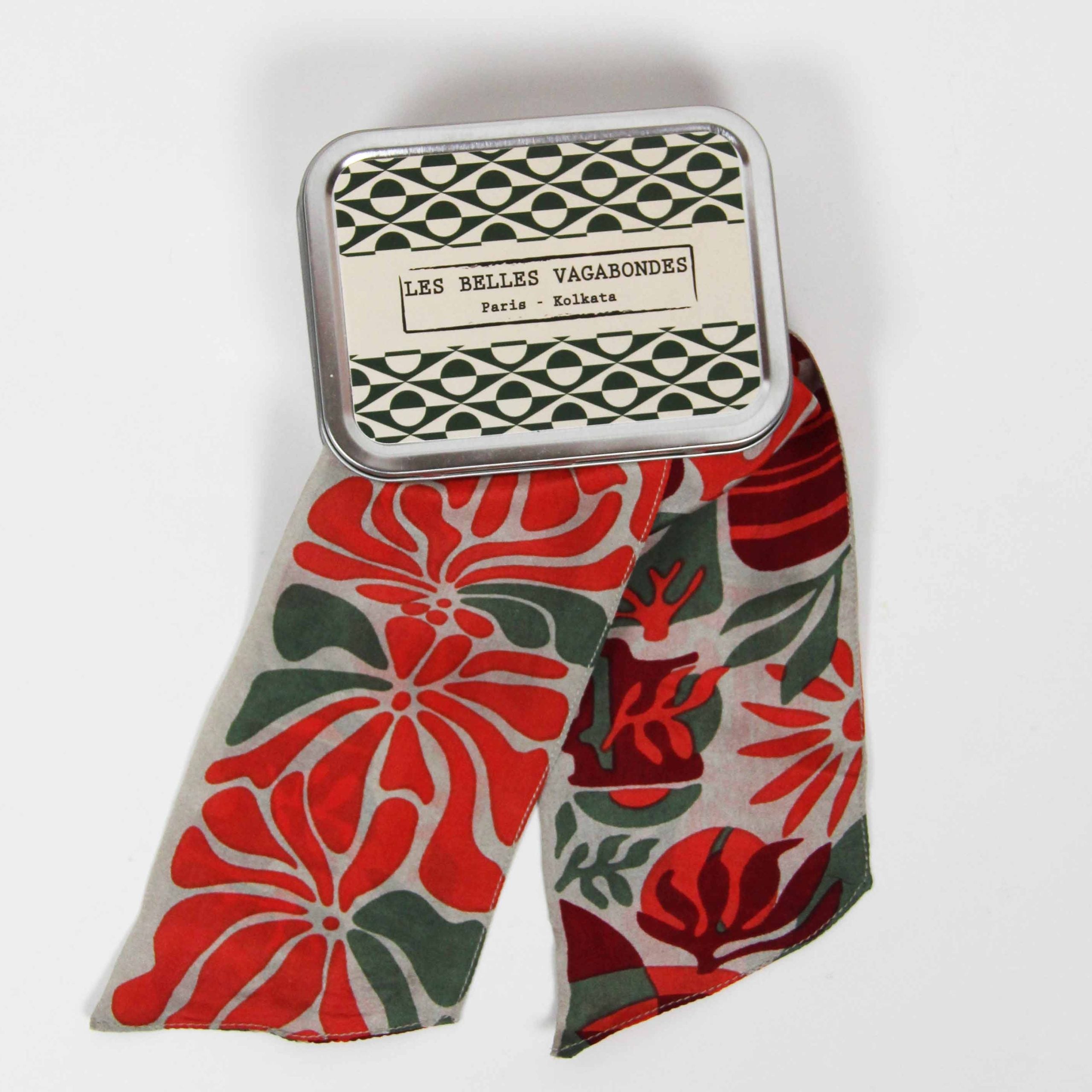 Floral-patterned fabric with a matching tin labeled 'LES BELLES VAGABONDES' on a white background