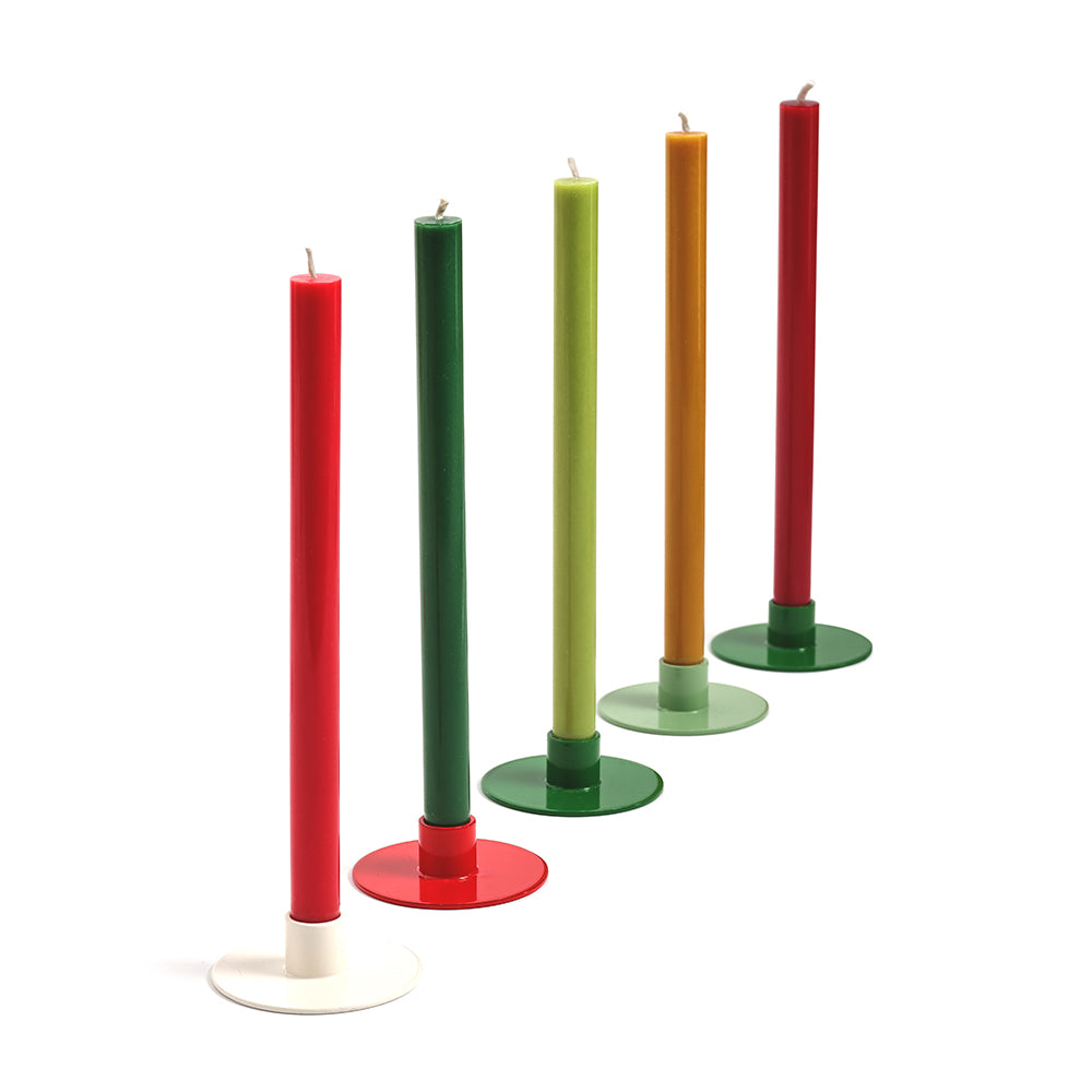 Set of colorful candles on stands against a white background