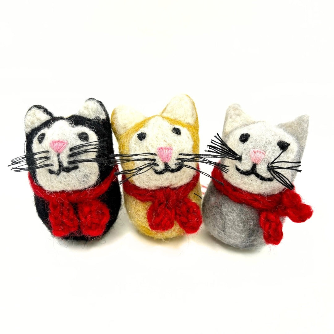 Three cat-shaped toys with red scarves on a white background