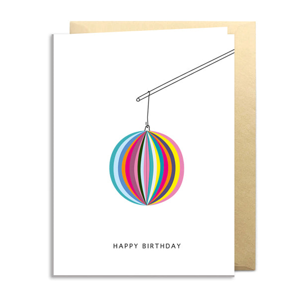 Greeting card with a colorful hanging ball design and 'Happy Birthday' text on a white background.