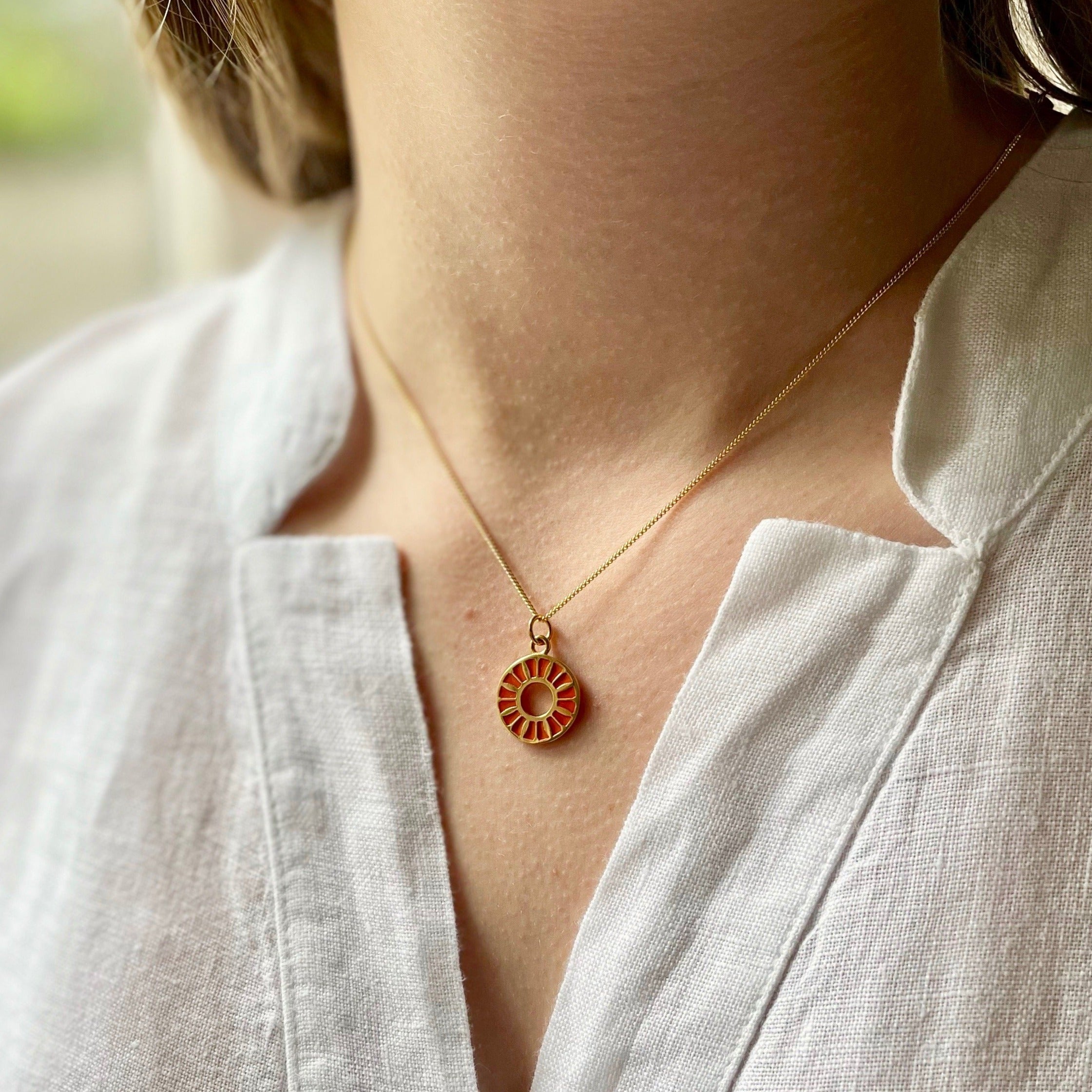 orange flower ring medallion in enamel on a neck