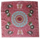 Decorative pink fabric with a central blue floral design and surrounding patterns