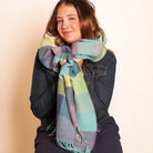 Woman wearing a colorful striped scarf against a beige background