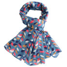 A lightweight scarf with a blue base and an allover abstract leaf pattern in navy, coral pink, mustard yellow, and white, styled in a loop on a plain white background.