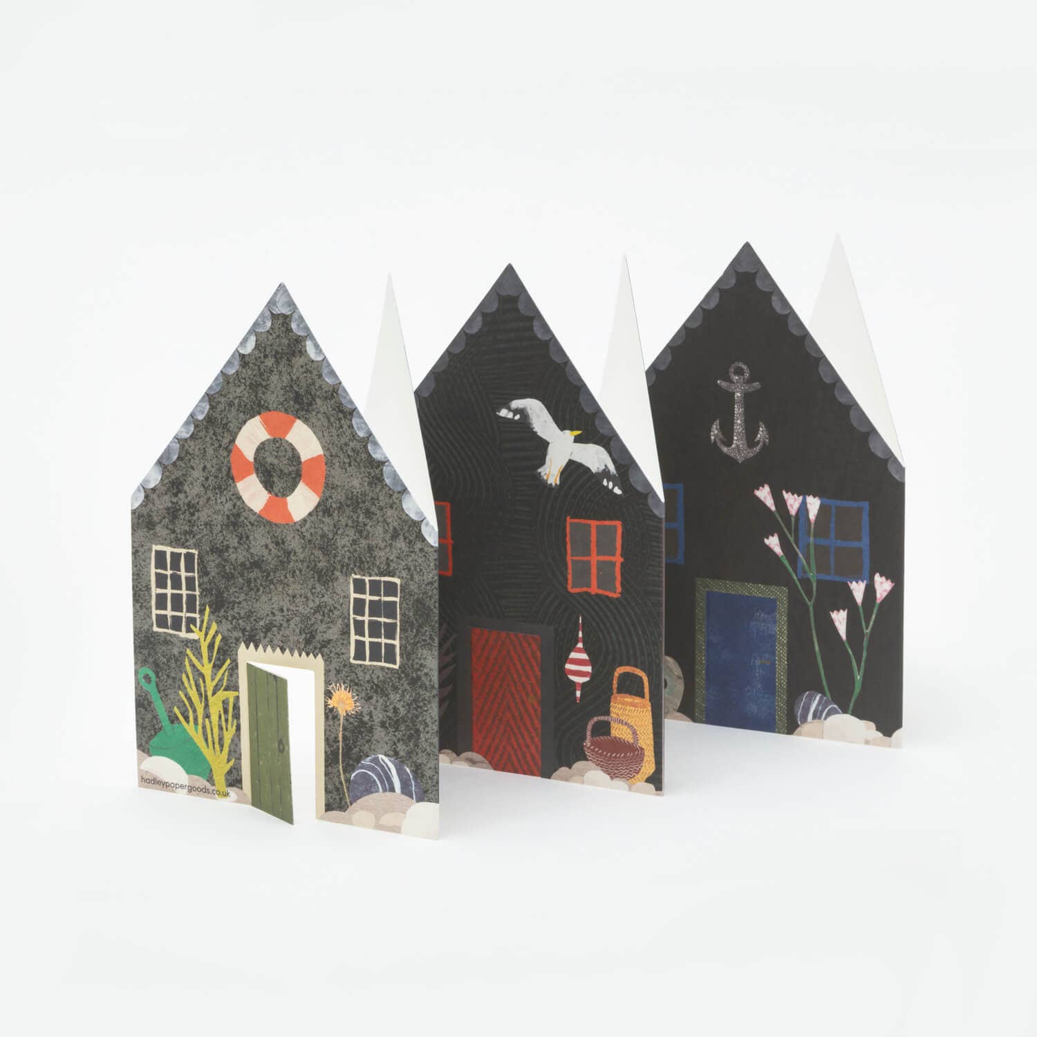 Three decorative paper houses with various designs on a white background