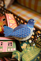 Decorative paper birds with colorful patterns on a wooden surface.