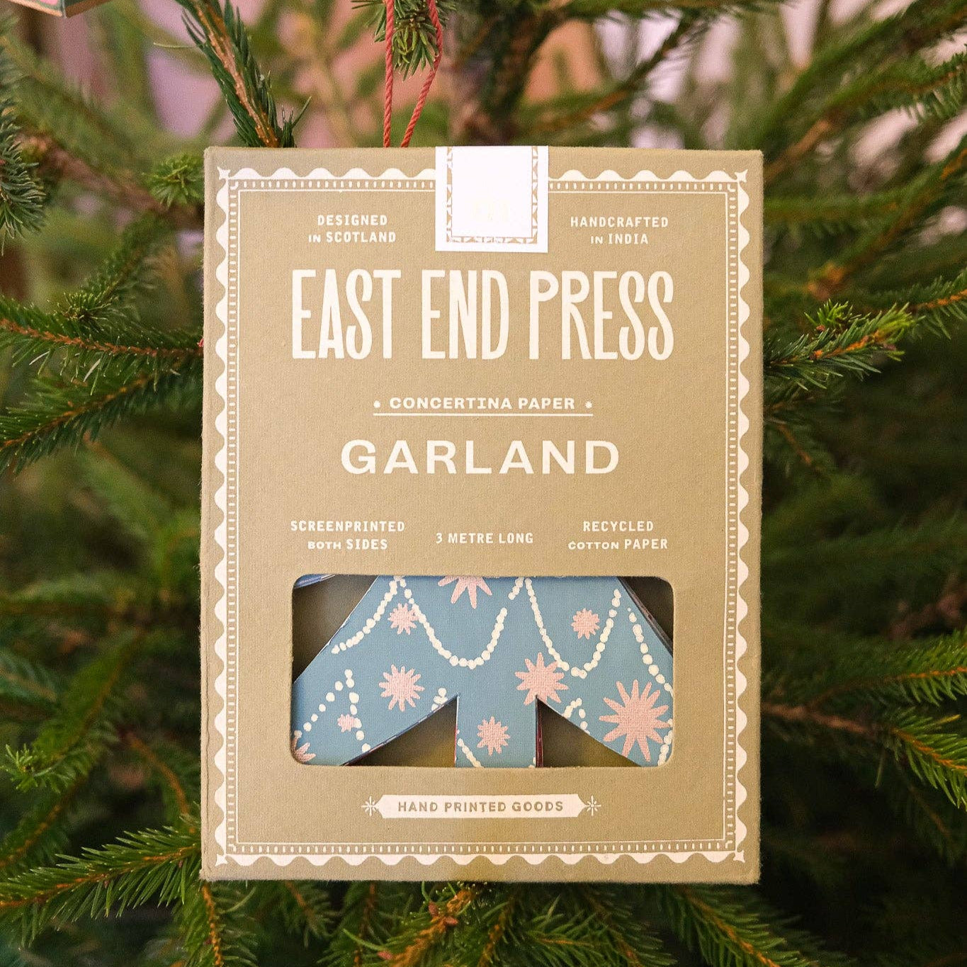 Box of East End Press Garland packaging on a green leafy background