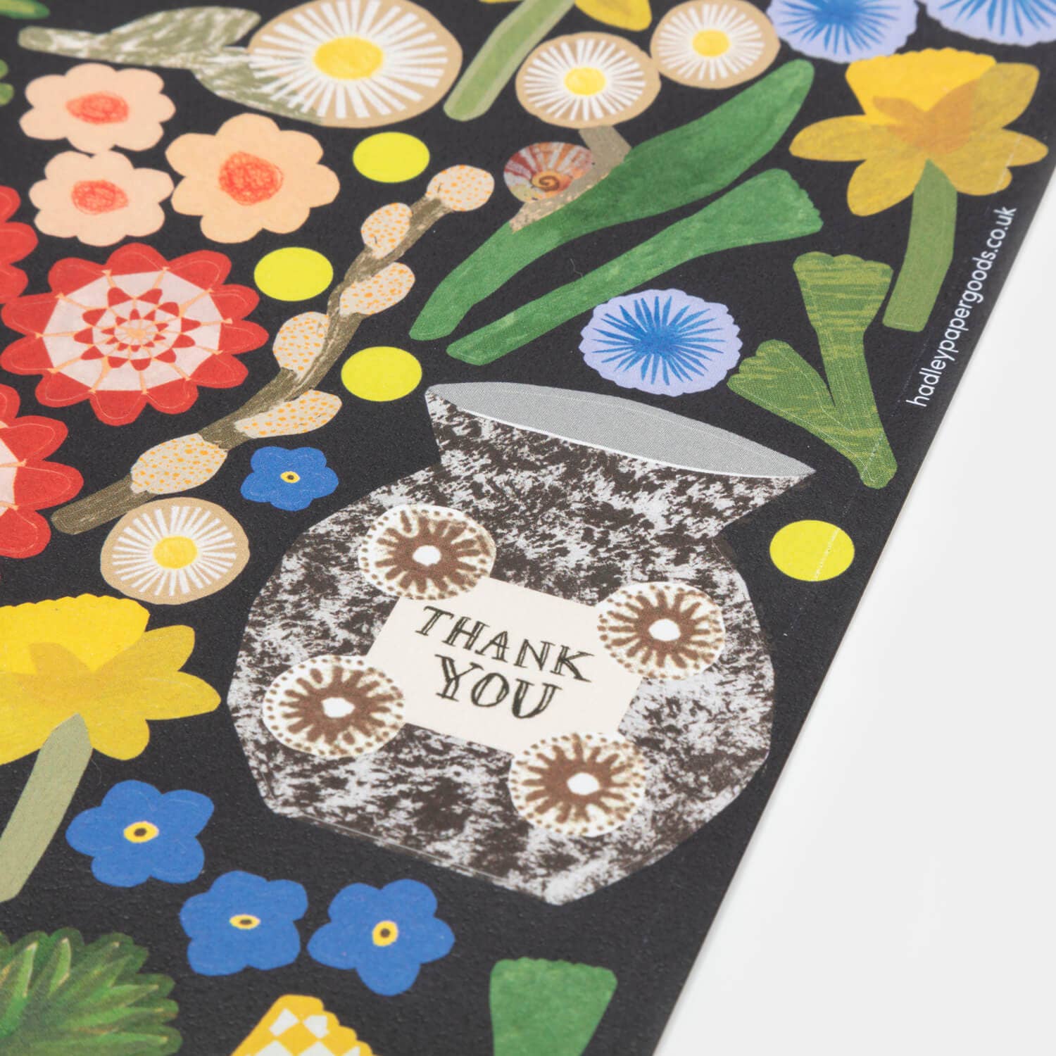 Colorful floral design with a 'Thank You' card on a black background
