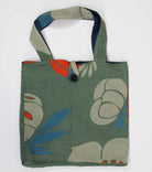 Green tote bag with floral design on a white background
