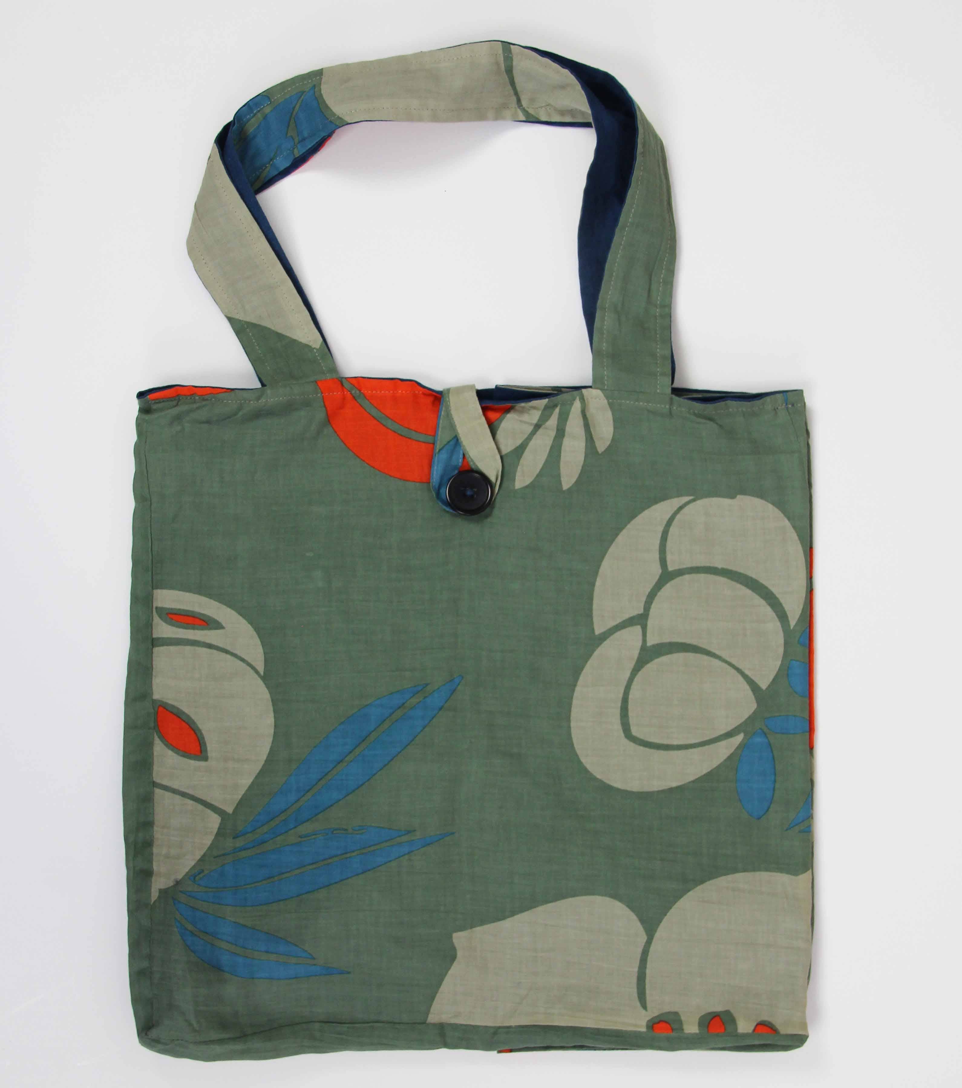 Green tote bag with floral design on a white background