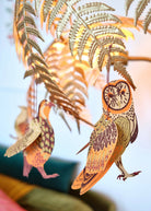 Decorative paper birds hanging from a branch with a blurred background