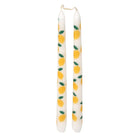 Two white candles with lemon pattern on a white background