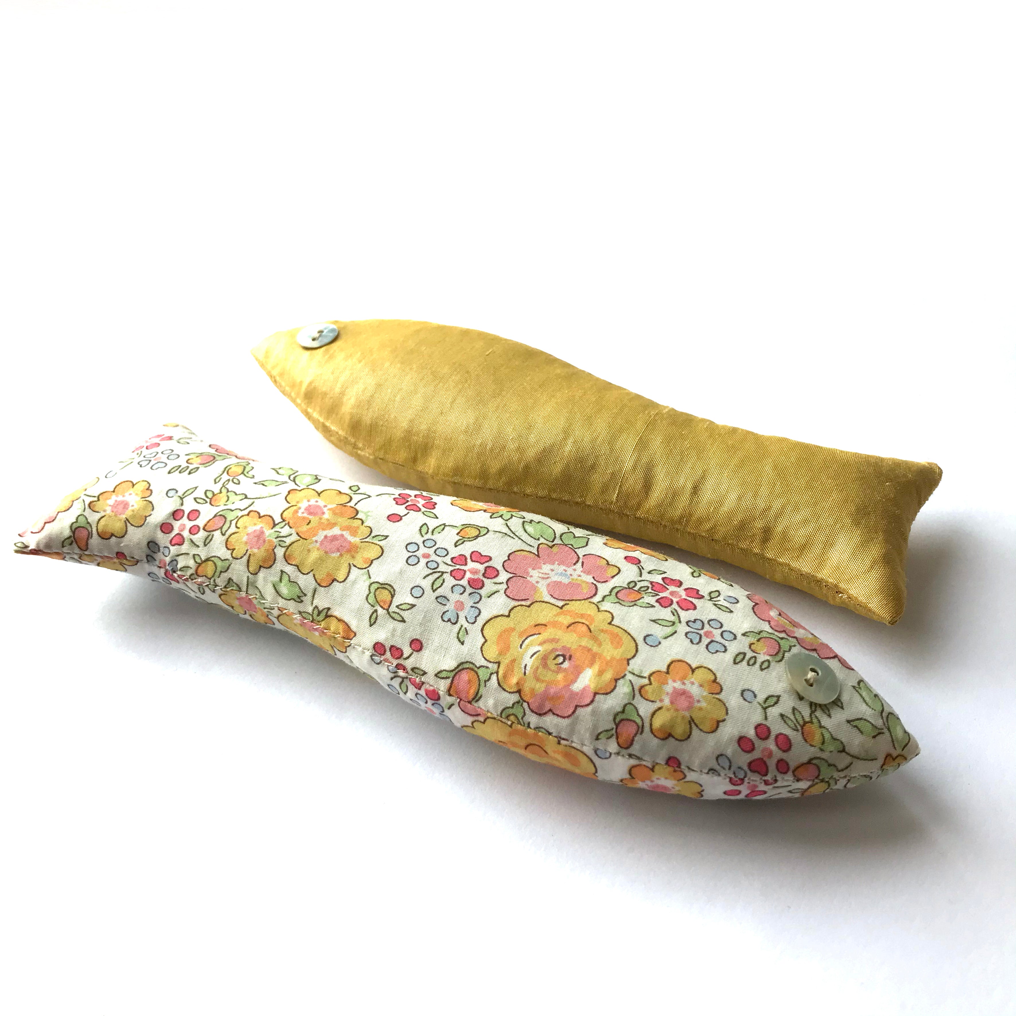 Two cotton sachets, one floral and one mustard yellow, on a white background