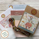 Craft kit with materials and a stitch guide on a wooden surface