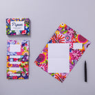 Colourful floral stationery set with a pen on a grey background