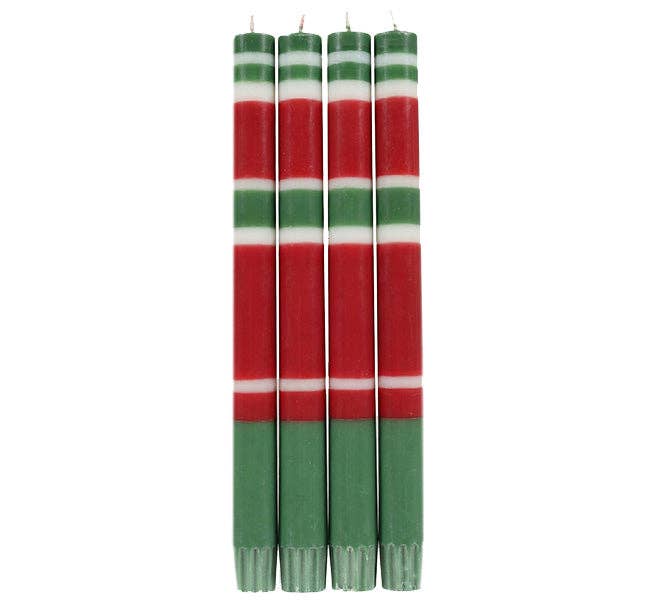 Four Christmas-themed taper candles with red, green, and white horizontal stripes, standing upright against a plain white background.