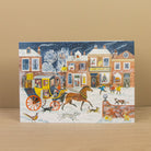 Illustrated Christmas card with a horse-drawn carriage and people in front of 'The Angel Inn' on a snowy street.
