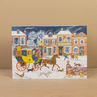 Card with a winter scene featuring a horse-drawn carriage and people in front of 'The Angel Inn'.