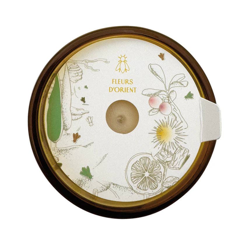 Round candle wax protector with floral designs and 'Fleurs d'Orient' text on a white background