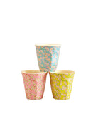 Three floral-patterned cups on a beige background